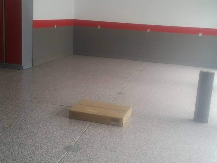 A clean garage interior with a speckled epoxy-coated floor and grey walls carrying a hand-painted red horizontal band at waist height.